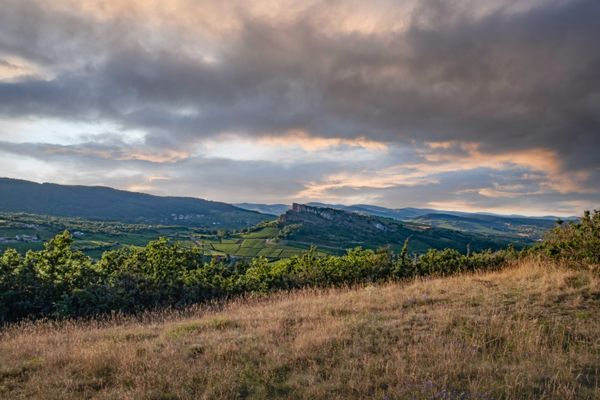 Un paysage de Bourgogne avec un rocher en arrière plan, au milieu des vignes